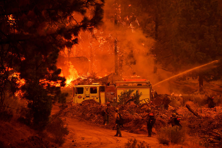 Firefighters work to control the Windy Fire as trees burn in the Sequoia National Forest near Johnsondale, Calif., on Sept. 22, 2021.