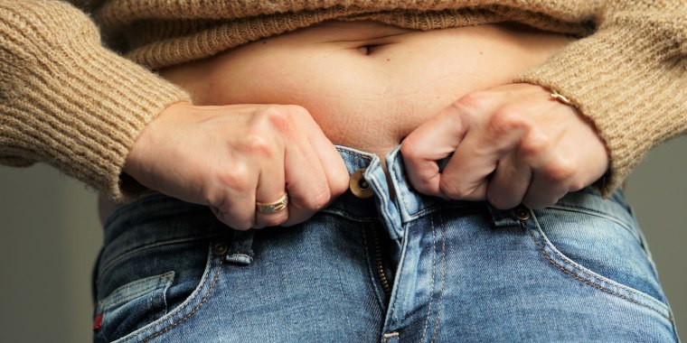 If you can’t fit into the same size trousers as when you were 21, you are carrying too much fat, a British researcher said.
