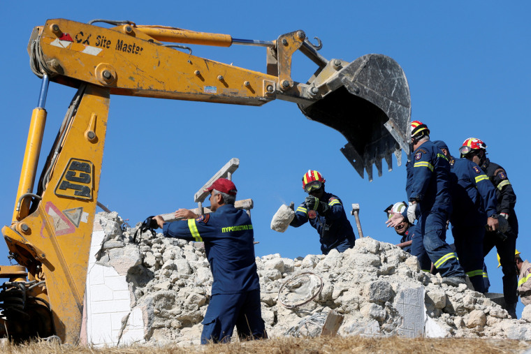 Image: Firefighters look for people in the rubble of a demolished church following an earthquake in Arkalochori.