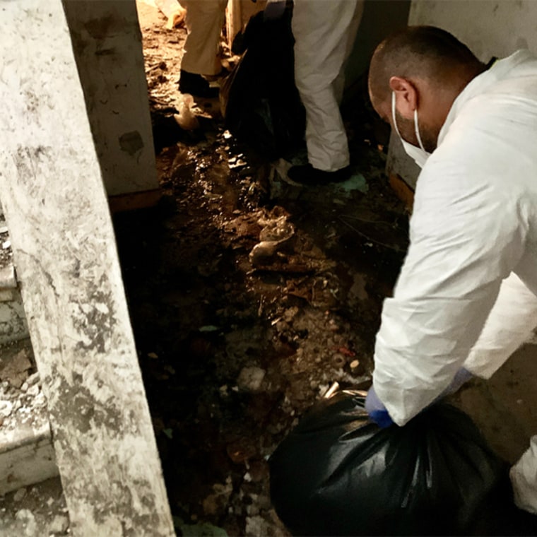 Image: Cleanup crews clean sewage, dirt and damage from the basement of Johnson Ho's apartment.