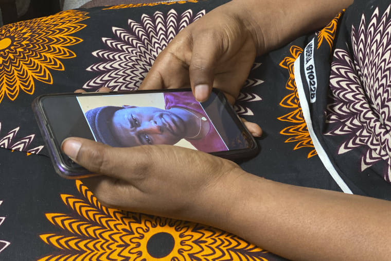 Anifa holds her phone displaying a photo of former World Health Organization doctor Boubacar Diallo of Canada. 
