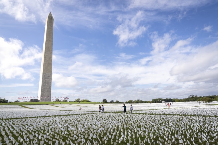 People walk through 'In America: Remember,' a public art installation commemorating all the Americans who have died due to Covid-19, on the National Mall Sept. 21, 2021 in Washington, DC.