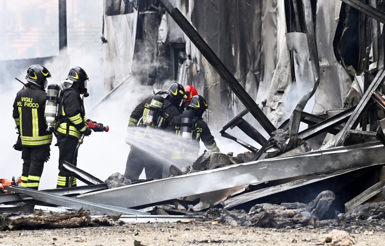 Firefighters work at the scene where a small plane crashed into a building in San Donato Milanese, Italy, on Oct. 3, 2021.