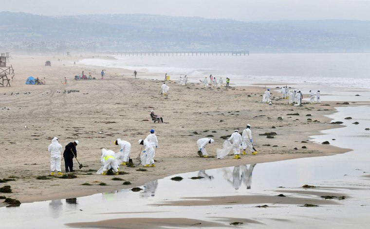 A cleanup crew works on the beach on October 7, 2021 in Newport Beach, California after up to 131,000 gallons of crude could leaked into the Pacific Ocean on the west coast of the United States when a pipeline ruptured over the weekend.