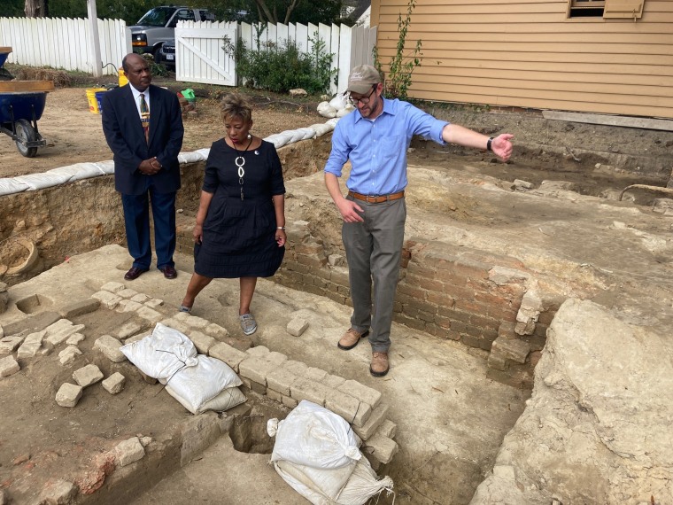 From left, Reginald F. Davis, pastor of First Baptist Church in Williamsburg, Connie Matthews Harshaw, a member of First Baptist, and Jack Gary, Colonial Williamsburg's director of archaeology, stand at the brick-and-mortar foundation of one the oldest Bl