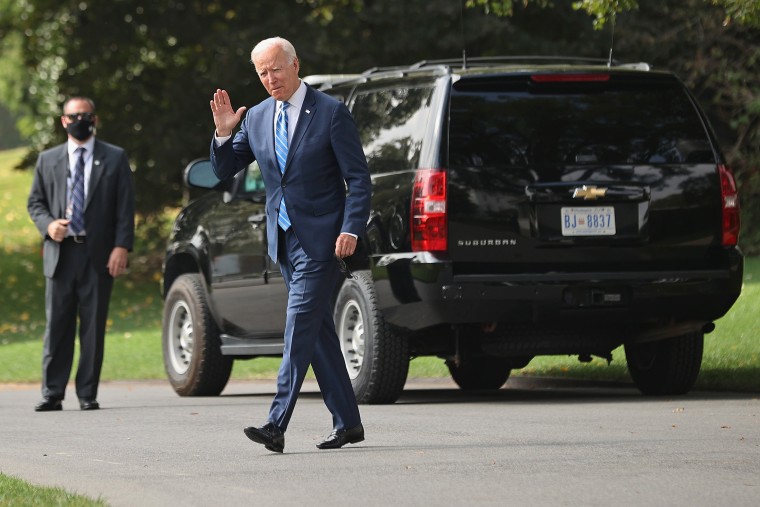 President Joe Biden waves to reporters as he departs the White House on Oct. 5, 2021.