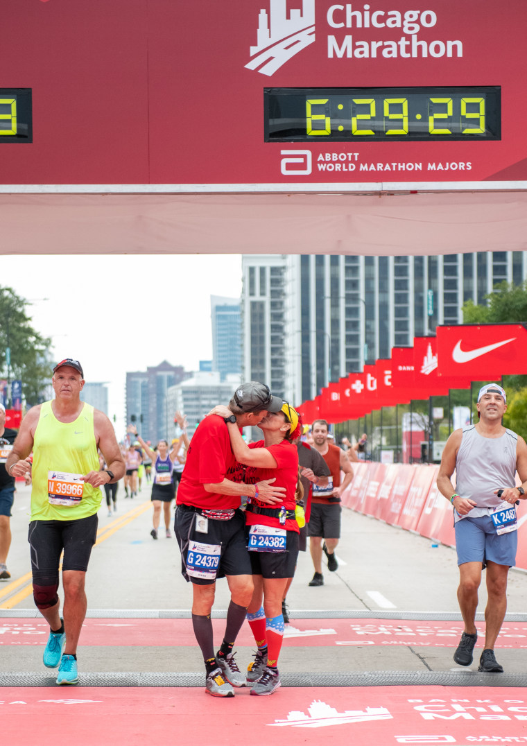 The couple paused for a kiss at the finish line on Sunday.