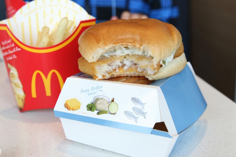 McDonald's fries and  Filet-o-Fish burger with a bite missing