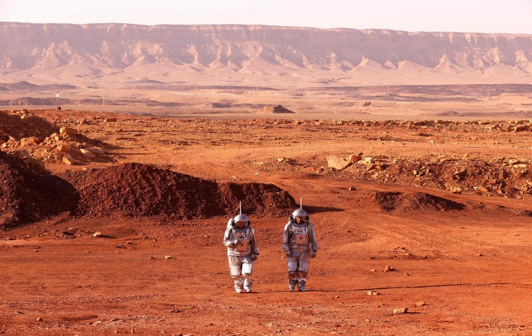 A couple of astronauts from a team from Europe and Israel walk in spacesuits during a training mission for planet Mars at a site that simulates an off-site station at the Ramon Crater in Mitzpe Ramon in Israel's southern Negev desert.