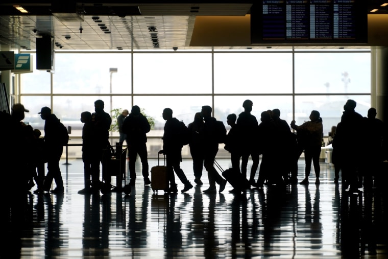 Image: Travelers walk through the Salt Lake City International Airport on March 17, 2021.