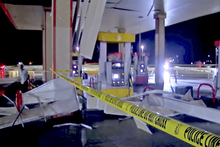 Debris from tornadoes pile around the pumps of a filling station late Sunday in Shawnee, Okla.