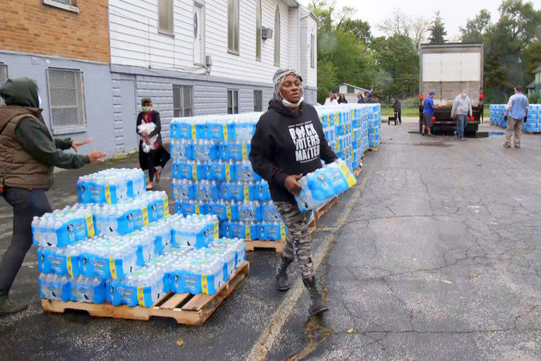 Image: A resident picks up bottled water at a distribution site, in Benton Harbor, Mich.