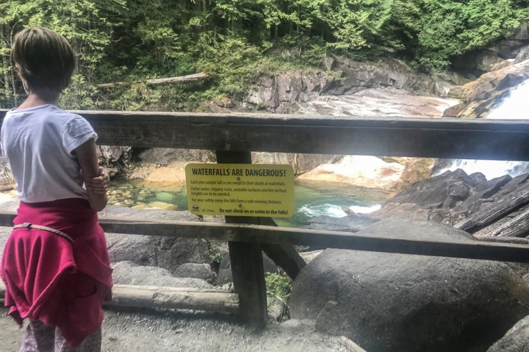 A warning sign posted for the waterfalls on the Lower Gold Creek Falls Trail from Golden Ears Provincial Park in British Columbia, Canada.