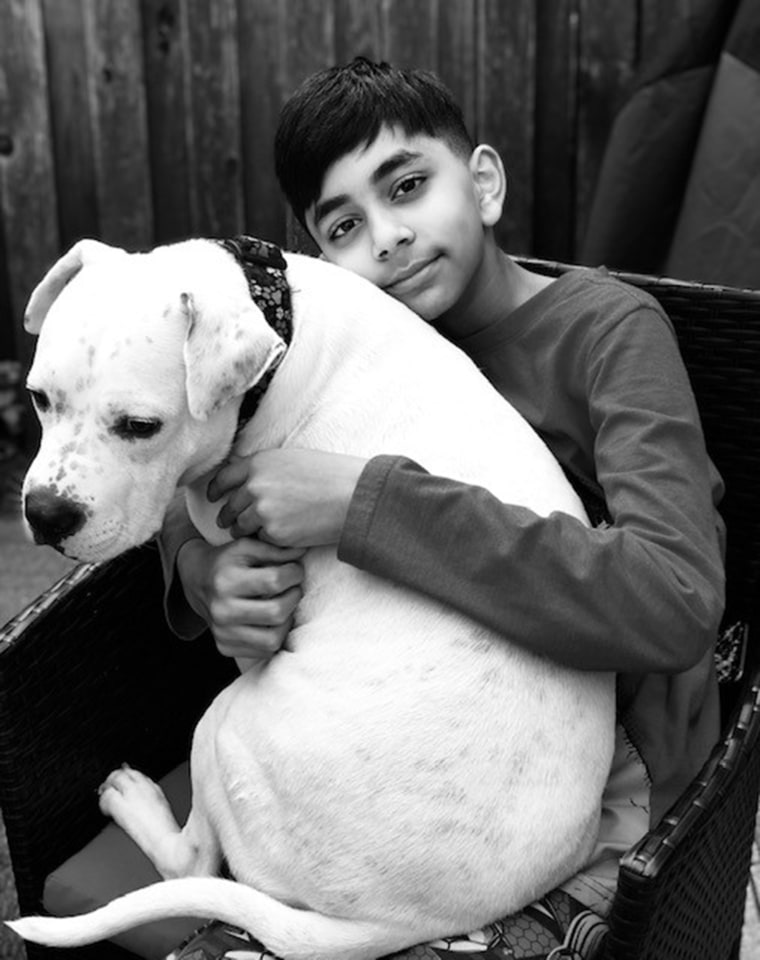 ASPCA Kid of the Year Evan Bisnauth snuggles a dog.