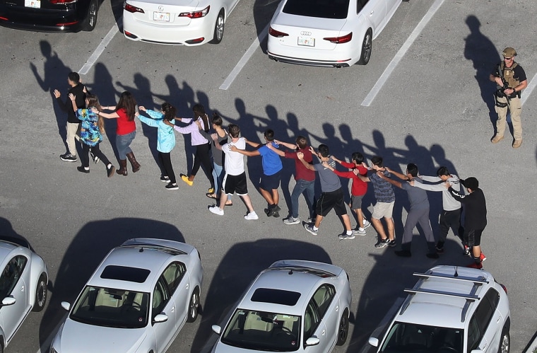 Image: People are brought out of the Marjory Stoneman Douglas High School after a shooting at the school that reportedly killed and injured multiple people