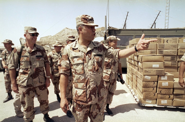 Gen. Colin Powell, Chairman of the Joint Chiefs of Staff, points to a group of American troops at an airbase after his arrival in Saudi Arabia on  Sept. 13, 1990.