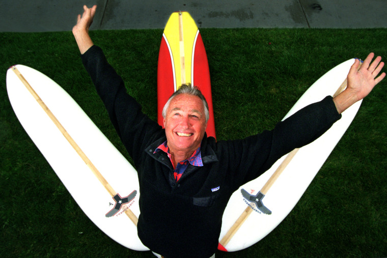 Image: \"Y\", formerly known at Tom Morey, flashes his signature pose with his new surfboard design. He is ma