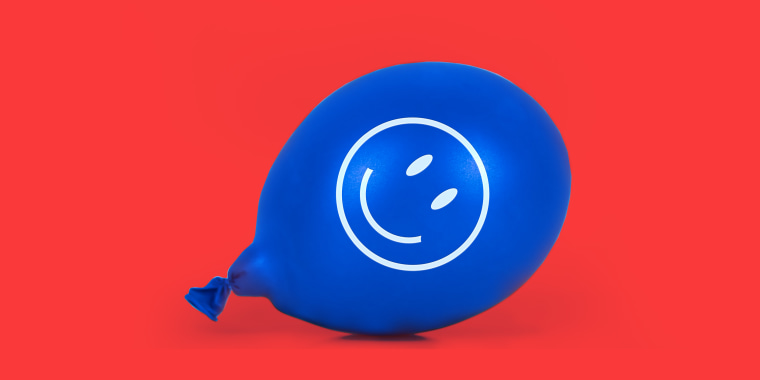 Photo illustration: A blue balloon with a smiley face lying on the floor.