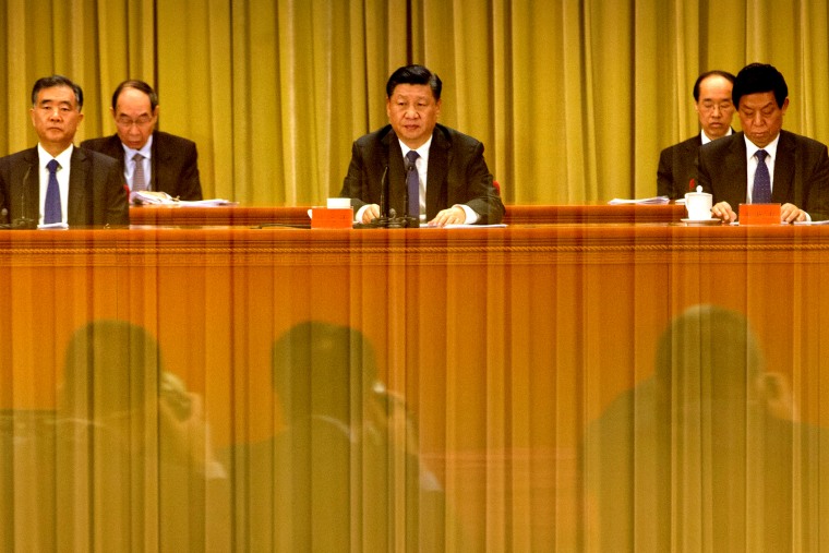 A banner is reflected on a polished surface as Chinese President Xi Jinping (C) speaks during an event to commemorate the 40th anniversary of the "Message to Compatriots in Taiwan" at the Great Hall of the People in Beijing