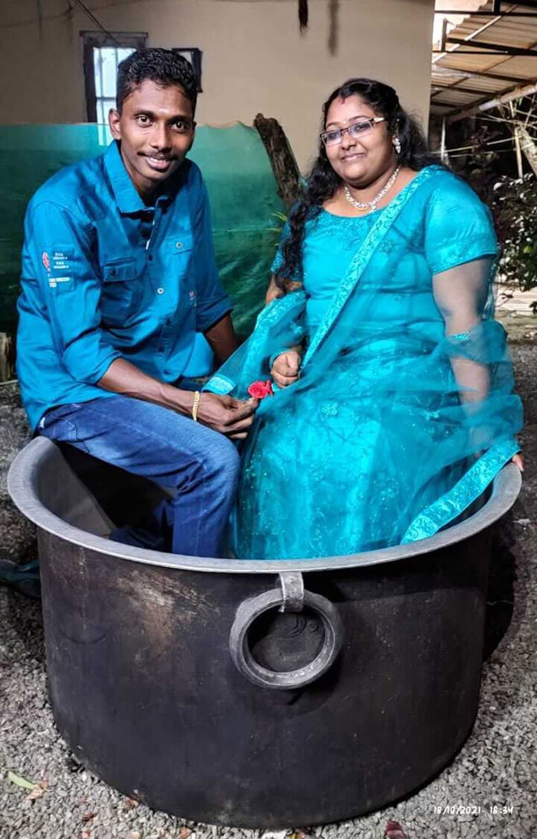 Akash and Aishwarya, an Indian couple who arrived for their wedding in unusual style after sailing through the flooded streets of their town in a cooking pot, Kerala state, India.