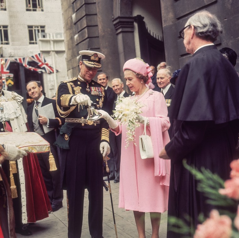 Queen Elizabeth II and Prince Philip admiring a silver bell during celebrations of her Silver Jubilee, marking 25 years in service, on June 7, 1977 in London.