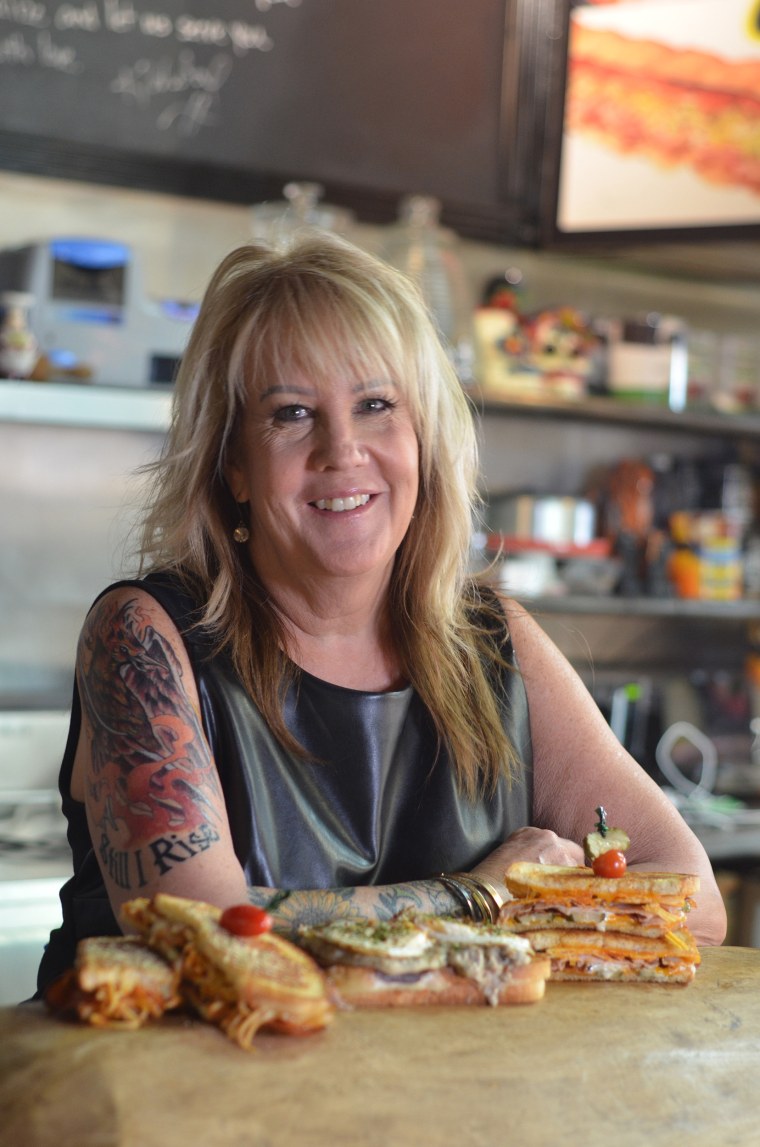 Kim Wilcox poses with grilled cheese in her Knoxville restaurant