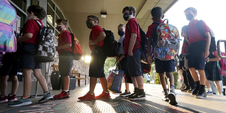 Elementary school students wear masks as they line up to enter school for the first day of classes in Richardson, Texas, on Aug. 17, 2021.
