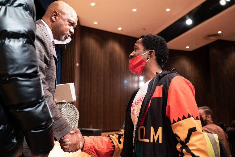 Image: Reverend Jerry McAfee shakes hands with an audience member at the North High School auditorium in Minneapolis on Oct. 12, 2021.