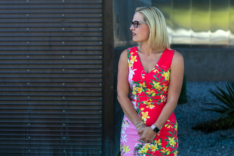 Rep. Kyrsten Sinema, D-Ariz., the Democratic candidate for the Senate, waits to greet voters at a polling place set up at the Burston Barr Central Library in Phoenix on Nov. 6, 2018.