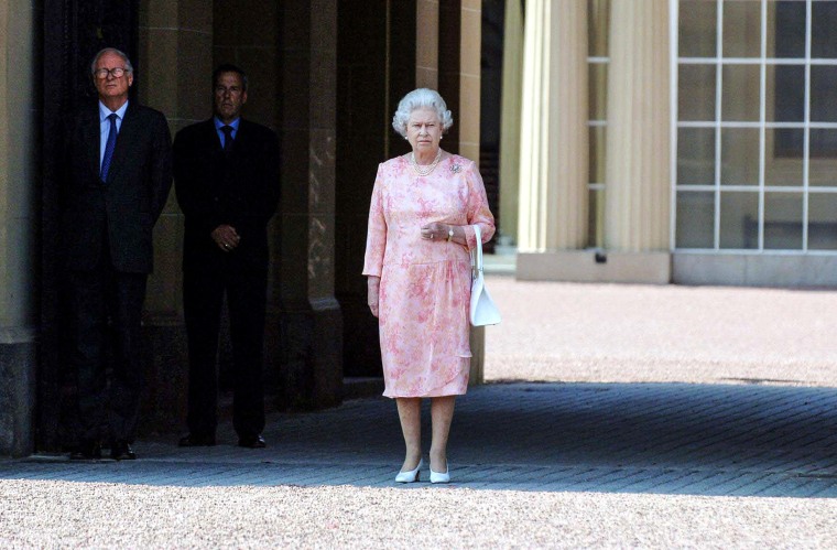 Britain's Queen Elizabeth stands in forecourt of Buckingham Palace as she observes two-minute silence in ...