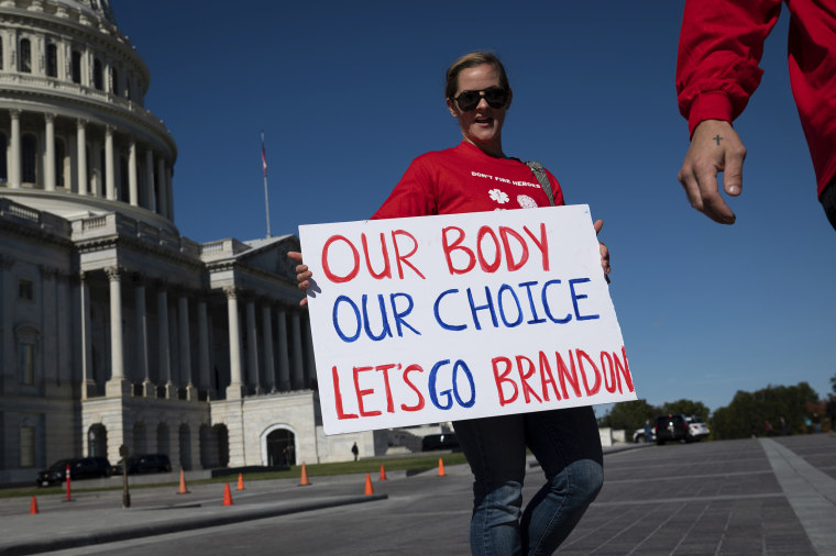 A first responder carries a sign reading "Our Body Our Choice Let's Go Brandon" before a press conference about vaccine mandates and first responders at the U.S. Capitol on Monday.