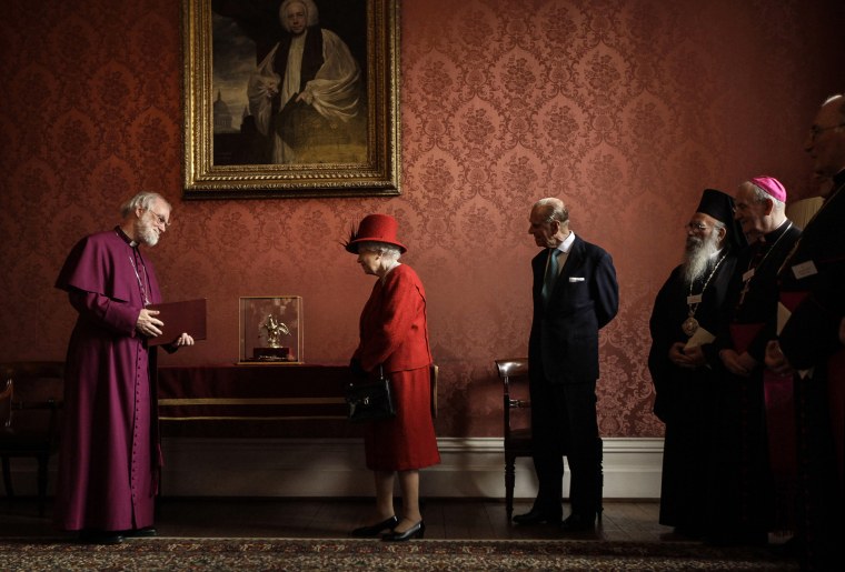 Britain's Queen Elizabeth II, second left, is shown the Ampulla and Coronation Spoon used at her coronation in 1953 by the Archbishop of Canterbury Rowan Williams, left, as her husband Prince Philip, third from left, and other Christian guests watch as they attend a multi-faith reception to mark the Diamond Jubilee of the Queen's Accession at Lambeth Palace in London on Feb. 15, 2012.