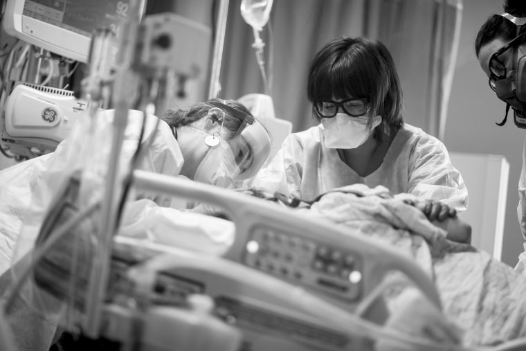 Image: Dr. Carrie Goodson left, comforts a patient as she is intubated, while nurses Ashley Vite, center, and Amy Cooper assist in the ICU Covid ward at the Medical Center of Aurora, in Colorado on May 27, 2020.