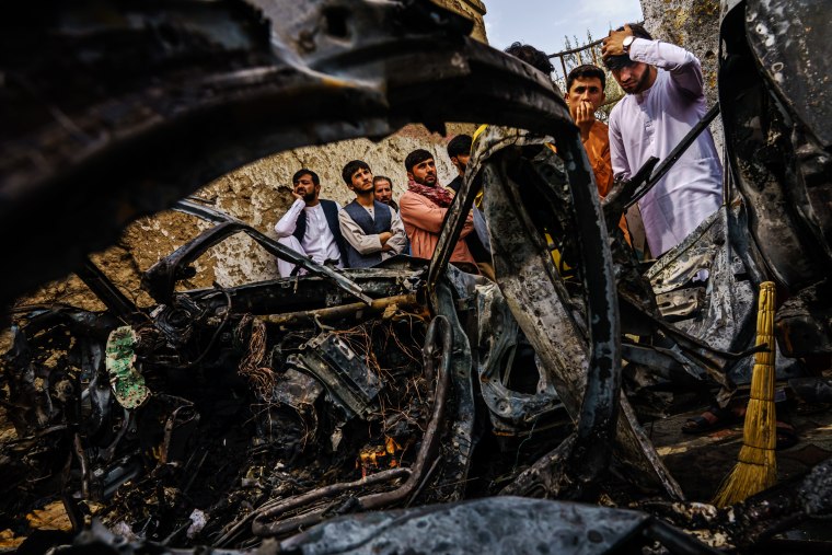 Image: Residents gather around an incinerated car that was hit by a U.S. drone strike in Kabul, Afghanistan, on Aug. 30, 2021.