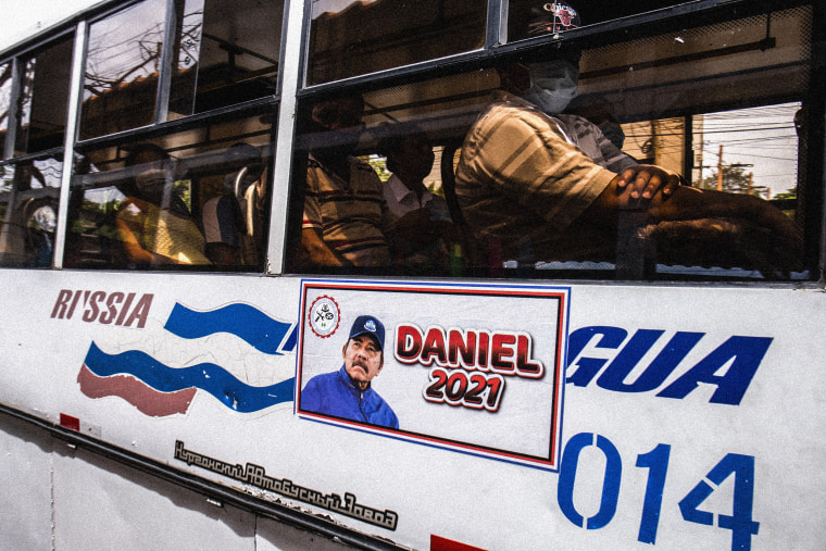 A man rides a bus with a Daniel Ortega campaign sticker on the side in Managua, Nicaragua on June 22, 2021.