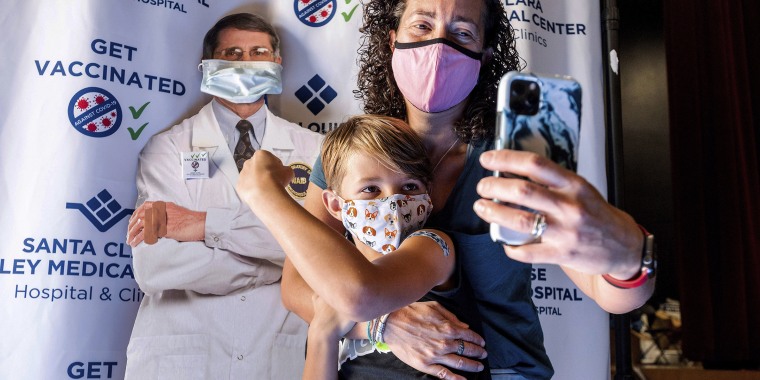 Finn Washburn, 9, shows off his arm as his mother, Kate Elsley, takes a photo shortly after he received a Pfizer-BioNTech COVID-19 vaccine in San Jose, Calif., on Nov. 3, 2021.