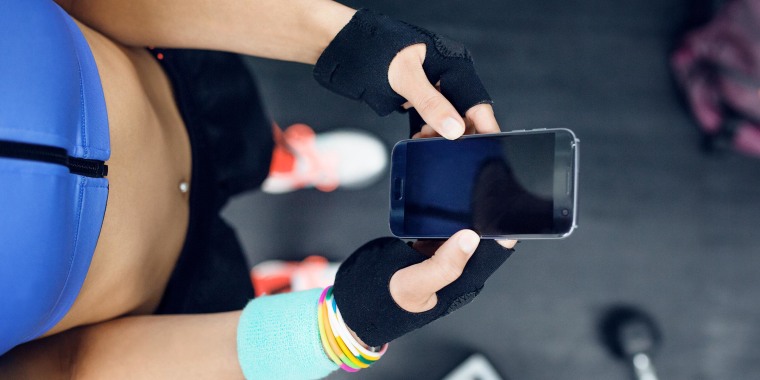 Overhead view of female athlete using smart phone at gym