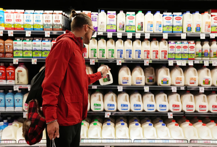 Image: A customer takes a gallon of milk for sale at a grocery store in Salt Lake City on Oct. 21, 2021.