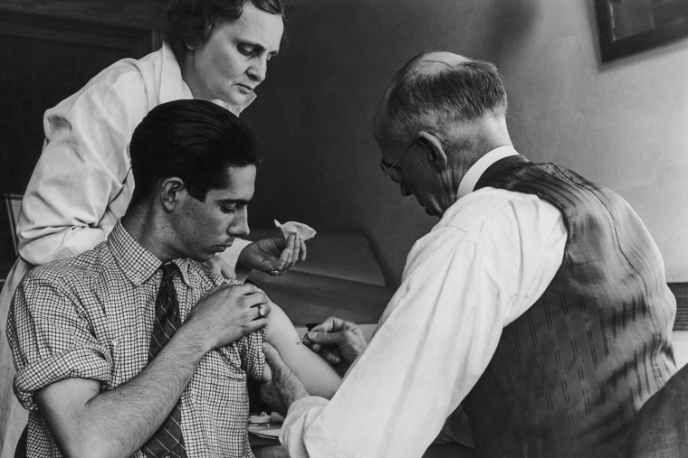 A boy is vaccinated against smallpox by a school doctor and a county health nurse in Gasport, N.Y., on March 15, 1938.