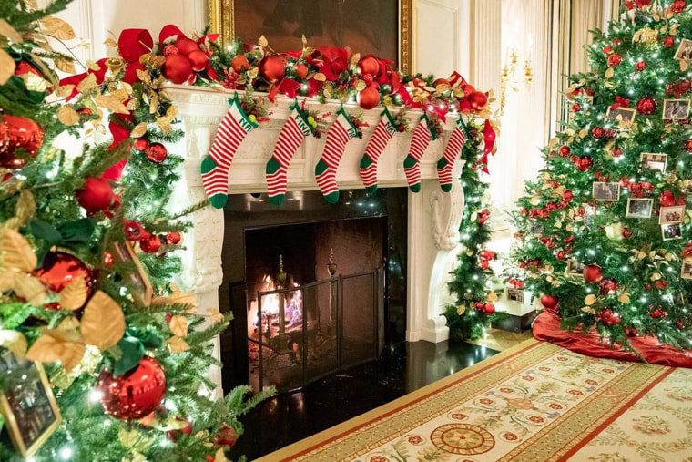 Christmas stockings for each of the Biden grandchildren — Naomi, Finnegan, Maisy, Natalie, Hunter and baby Beau — hang from the fireplace mantel in the State Dining Room.