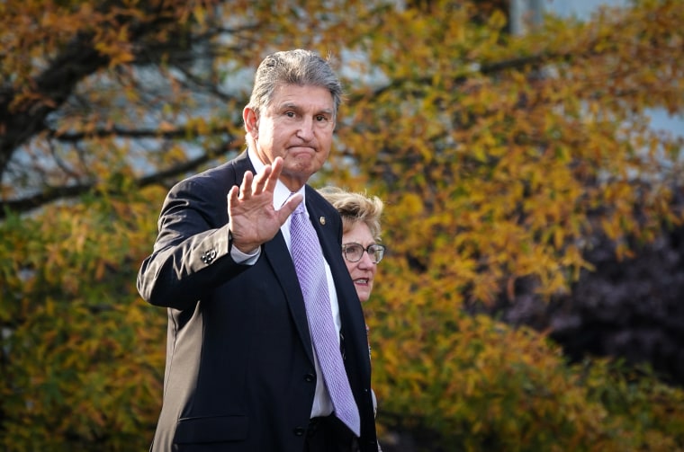 Image: Senator Joe Manchin, D-W.Va., waves while walking outside the West Wing of the White House on Nov. 18, 2021.