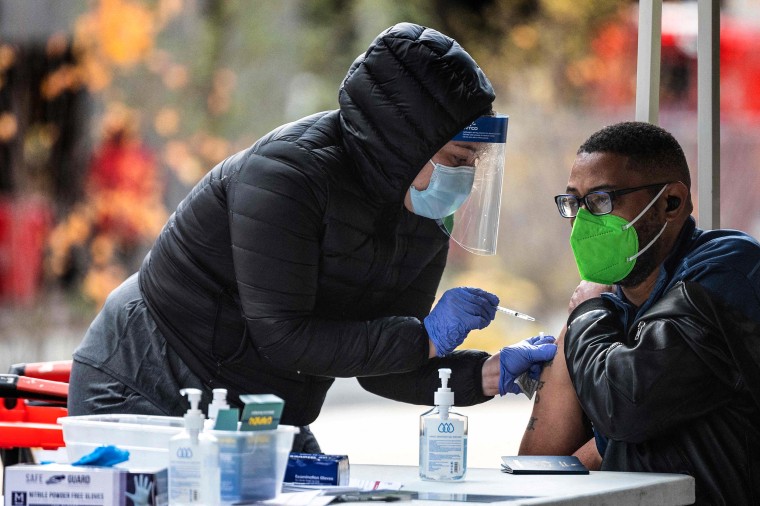 Image: A man gets his Covid-19 vaccination at an outdoor walk-up vaccination site within Franklin Park in Washington, DC, on Nov. 29, 2021.