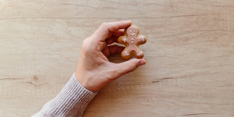 Holding gingerbread man cookie in hand, personal perspective view
