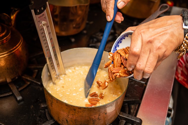 Harris adds her pecans to the sugar, cream and butter mixture.