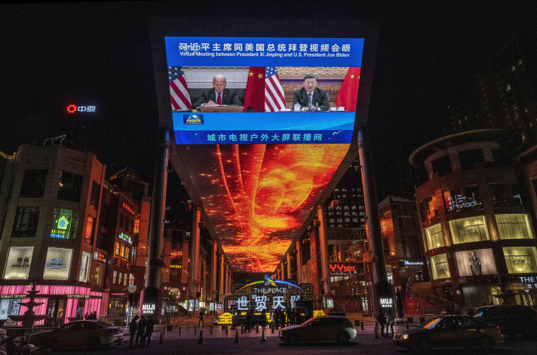 Image: A large screen displays President Joe Biden and China's President Xi Jinping during a virtual summit during a CCTV news broadcast outside a shopping mall on Nov. 16, 2021 in Beijing.