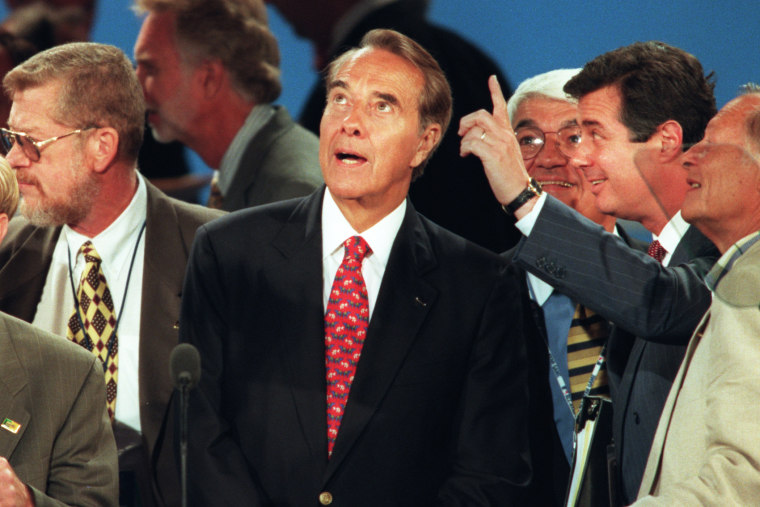 Republican presidential candidate Bob Dole looks up from podium at balloons and television cameras as convention center manager Paul Manafort, second from right, points out preparations for that night's acceptance speech in San Diego, Calif., on Aug. 15,