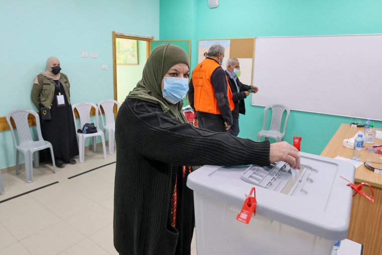 Image: A woman casts her vote at a polling station during municipal elections in the village of Baitain, on Dec. 11, 2021.
