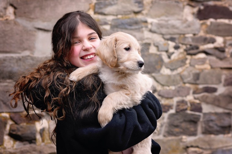 A girl holds a wish puppy.