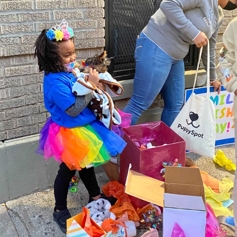 Camila with Cocomelon and other Make-A-Wish and PuppySpot gifts.