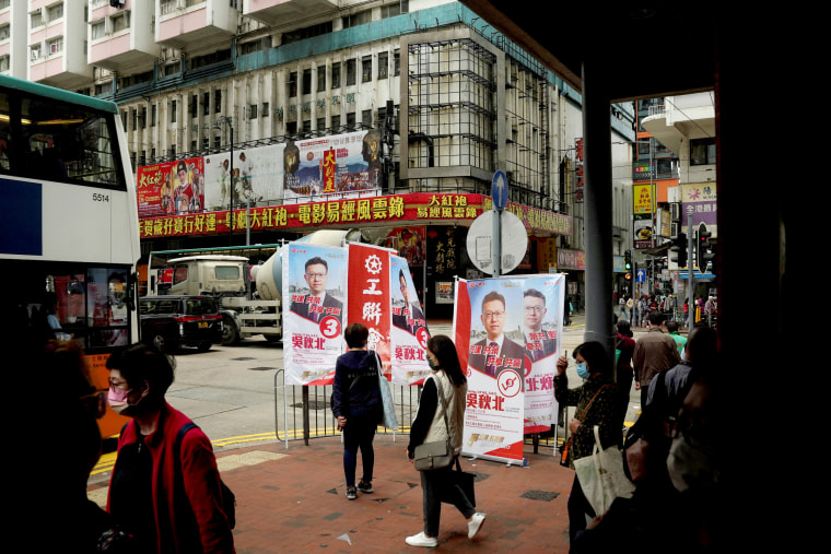 Image: Pedestrians walk past advertisements promoting FTU candidate Stanley Ng Chau-pei before the Legislative Council election in Hong Kong